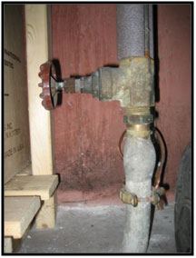 A lead service line entering a basement wall and connecting to a valve, from EPA.