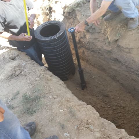 An excavated yard showing a water meter can and a curb stop can, where the service line runs.